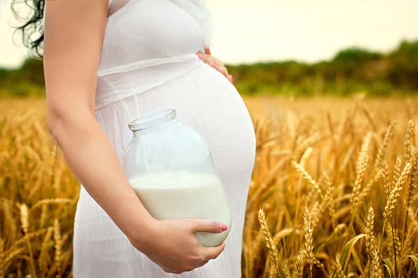 Беременная женщина с банкой молока